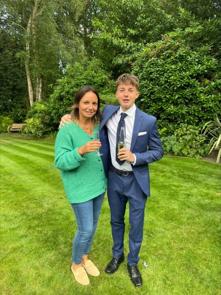 Vickie and her teenage son standing next to each other in the garden. He's wearing a blue suit and has his arm round Vickie.