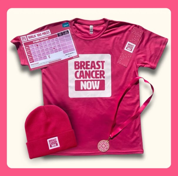 A pink t-shirt laid out with a pink beanie hat, medal, bookmark and a distance tracker for Walk 100 Miles on top. They all have Breast Cancer Now branding.