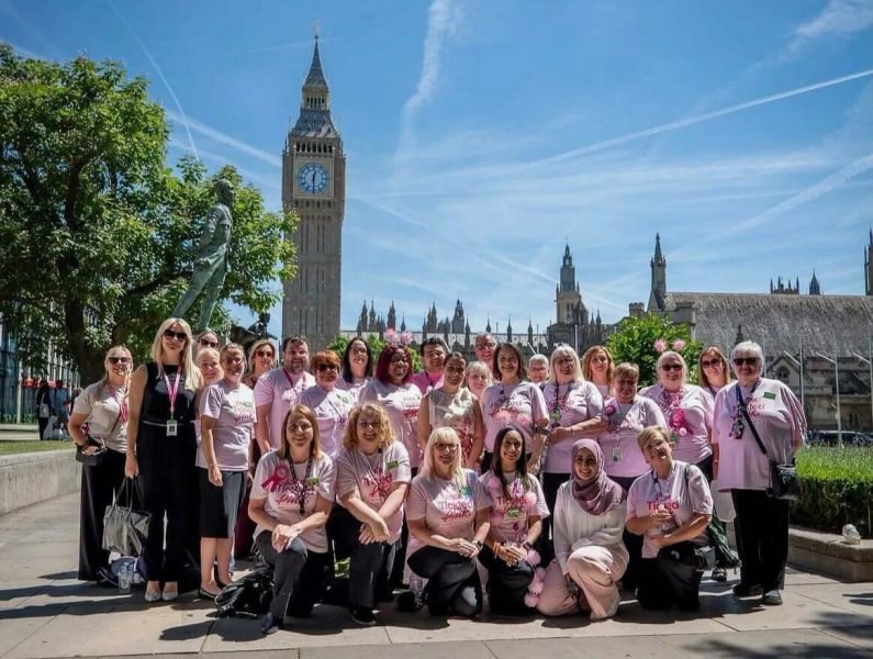 A large group of women wearing Asda Tickled Pink t-shirts outside the Palace of Westminster.