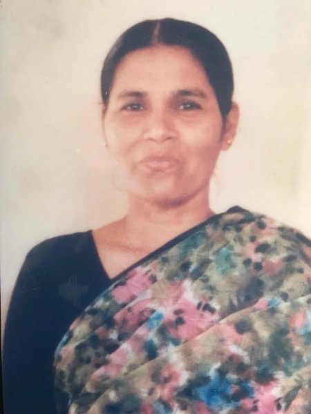 A portrait photo of Amit's mum, Rehka, wearing a floral print sari.