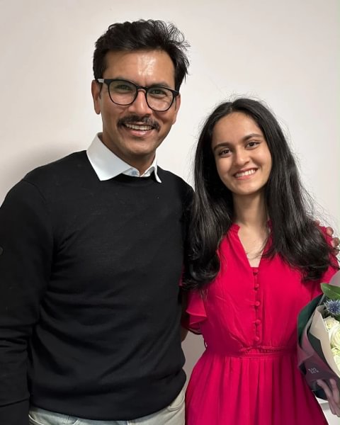A photo of a man and woman standing next to each other, smiling.