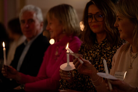 Photos of the carols concert, people singing, holding candles and enjoying the concert.