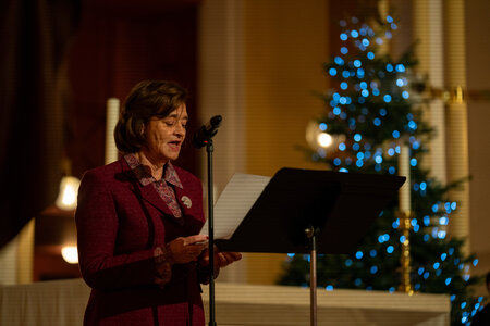 Photos of the carols concert, people singing, holding candles and enjoying the concert.