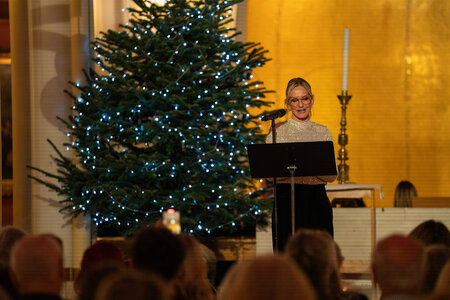 Photos of the carols concert, people singing, holding candles and enjoying the concert.