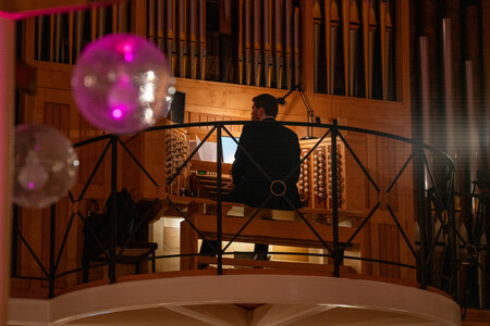 Photos of the carols concert, people singing, holding candles and enjoying the concert.