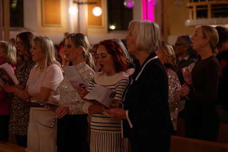 Photos of the carols concert, people singing, holding candles and enjoying the concert.