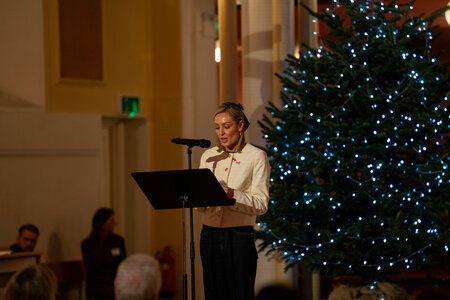 Photos of the carols concert, people singing, holding candles and enjoying the concert.