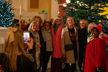 People socialising, drinking mulled wine and eating mince pies after the carols concert.