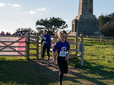 Participants running across the clifftops