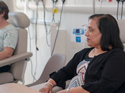 Bal, a woman with dark hair, preparing to receive chemotherapy in a chair at St Barts hopsital.