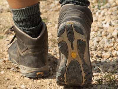 Photo of someone walking on a trail. The photo is a close-up of their walking boots.