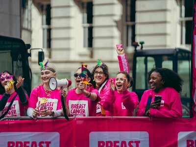 People wearing Breast Cancer Now pink running tops whilst running in the street at the London Landmarks half marathon.