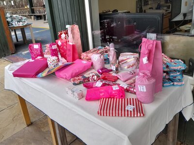A photo of a table with raffle prizes, all wrapped in pink wrapping paper.