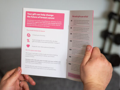 A man is holding Breast Cancer Now's Gifts in Wills booklet open on a page titled 'Your gift can help change the future of breast cancer.'
