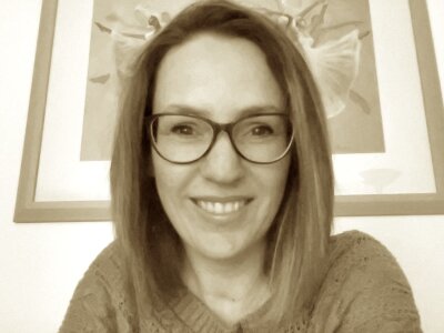 A photo of Rachel Lines. She has shoulder length hair and glasses, and is smiling