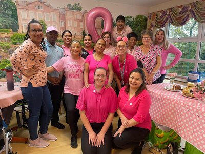 A group of people smiling at a Wear It Pink fundraising event.