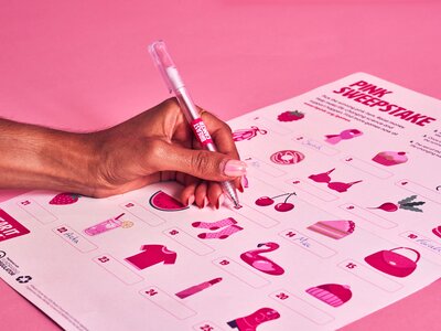 Wear it Pink sweepstake poster being completed, set against a light pink backdrop.