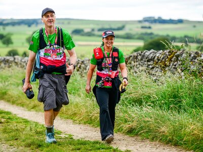 A photo of a man and a woman walking along a country path as part of the Peak District Ultra Challenge.