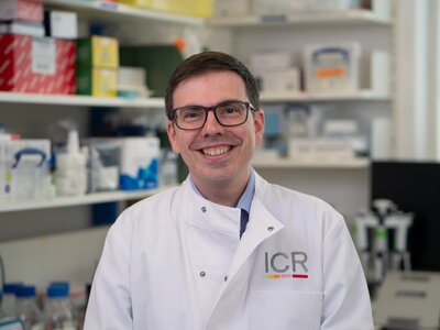 Researchers in white ICR lab coats in posing for photos in a lab.