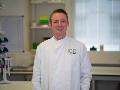Researchers in white ICR lab coats in posing for photos in a lab.