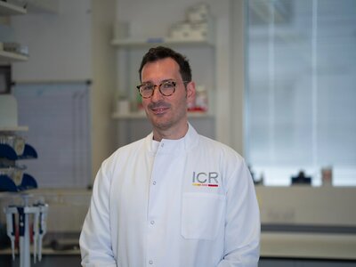 Researchers in white ICR lab coats in posing for photos in a lab.