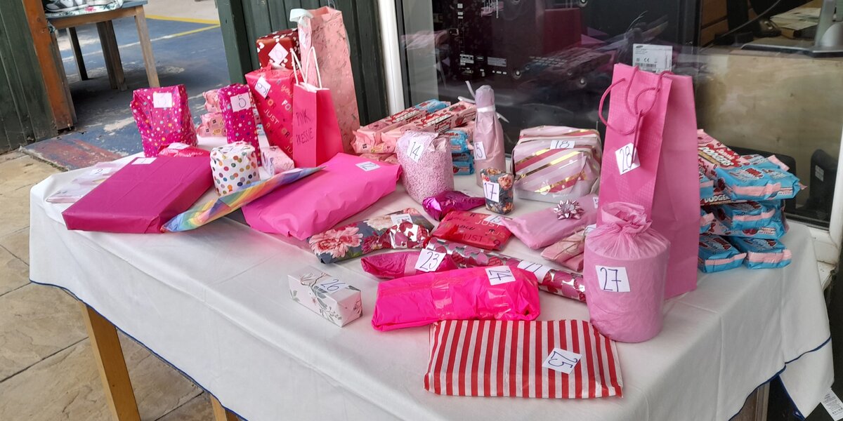 A photo of a table with raffle prizes, all wrapped in pink wrapping paper.