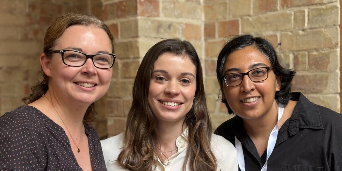 A photo of three researchers, Amy Llewellyn, Kalnisha Naidoo and Sophie Acton, smiling.