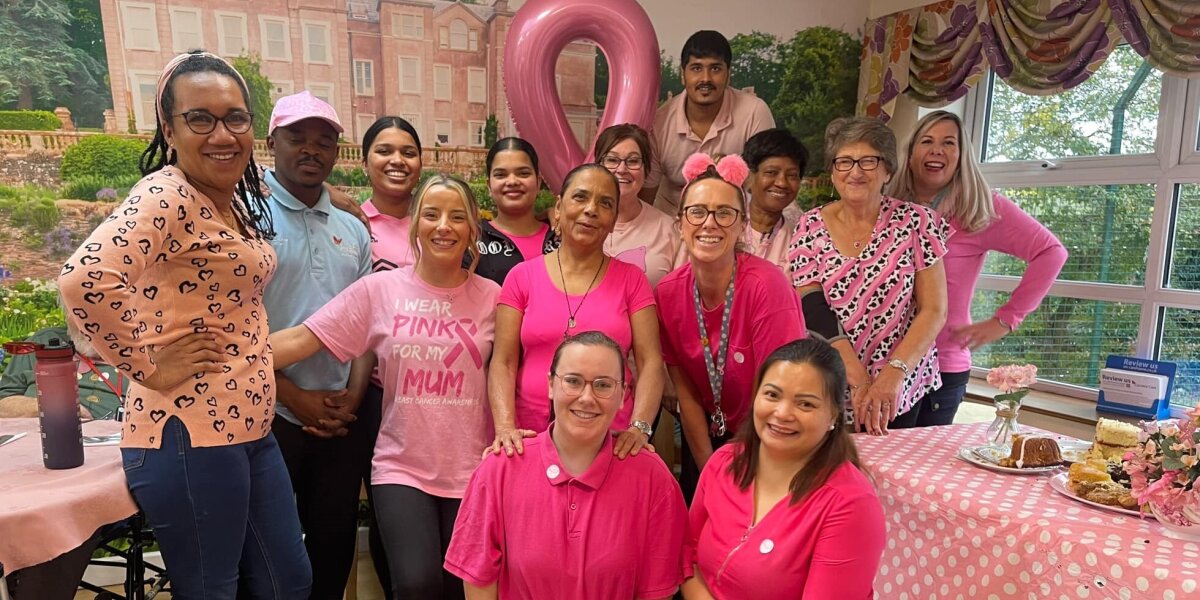 A group of people smiling at a Wear It Pink fundraising event.