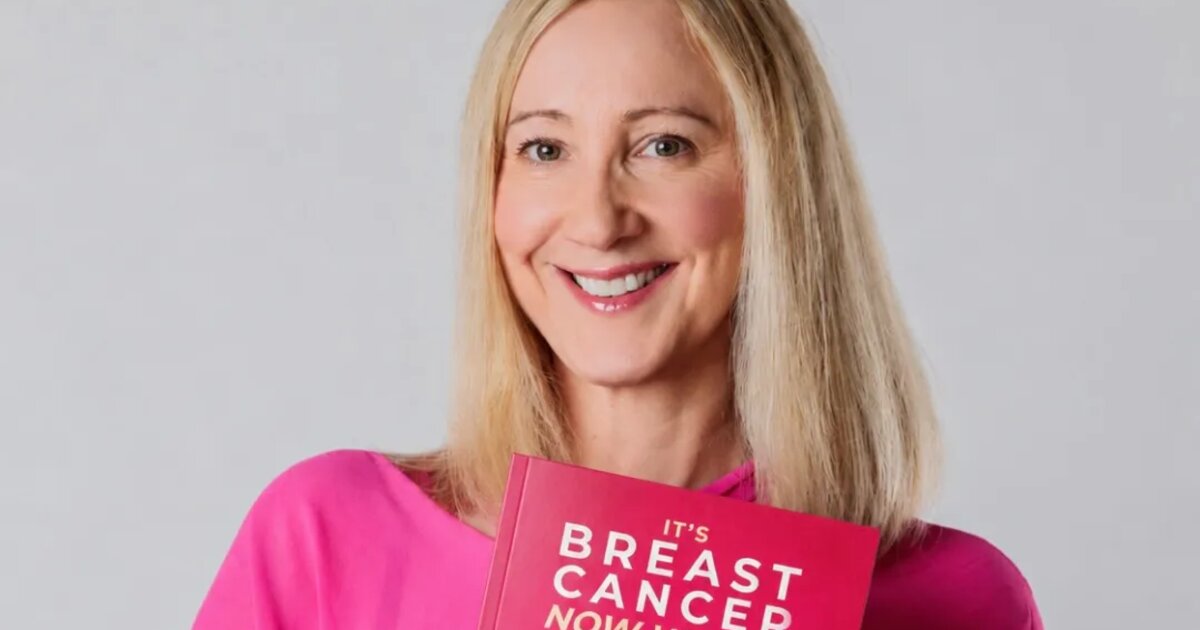 Christina Wilhelm is wearing a pink blouse and holding her book called 'It's Breast Cancer. Now What?' with the subtitle 'The missing manual for informed decisions, return to work and long-term recovery'