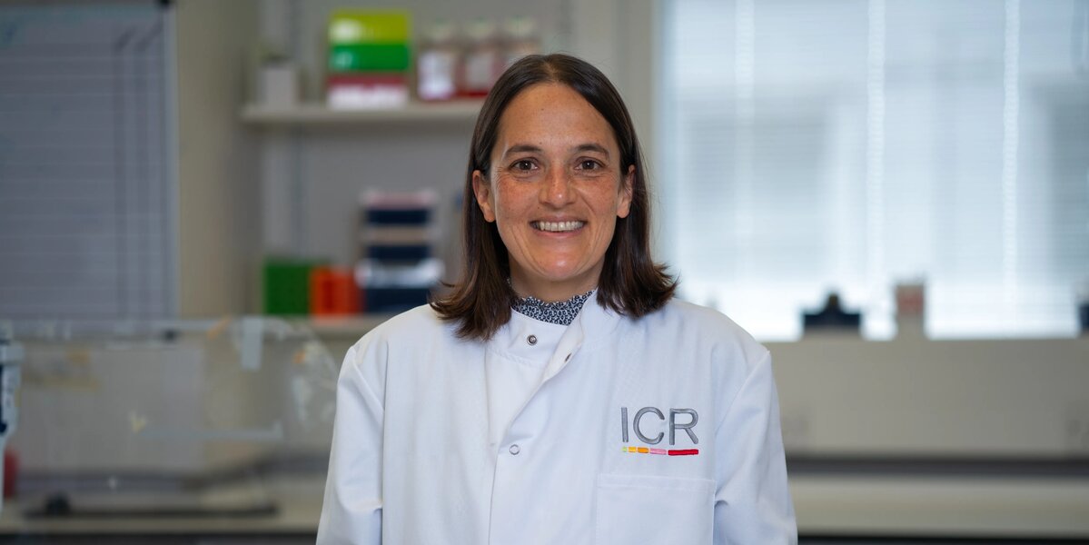 Researchers in white ICR lab coats in posing for photos in a lab.