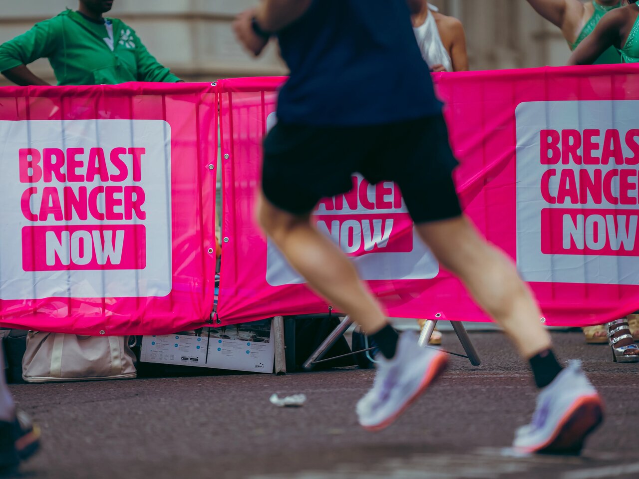 People wearing Breast Cancer Now pink running tops whilst running in the street at the London Landmarks half marathon.