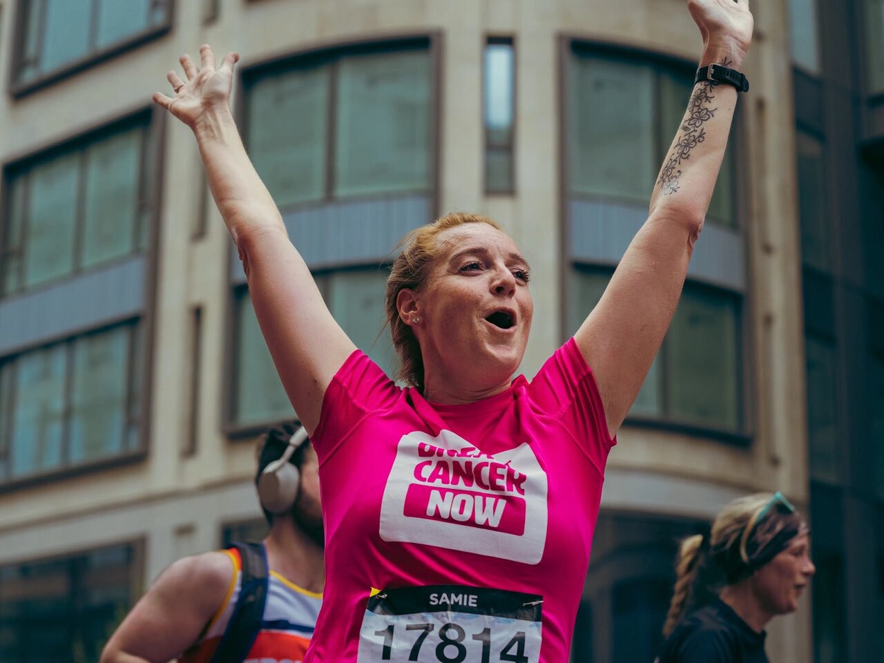 People wearing Breast Cancer Now pink running tops whilst running in the street at the London Landmarks half marathon.