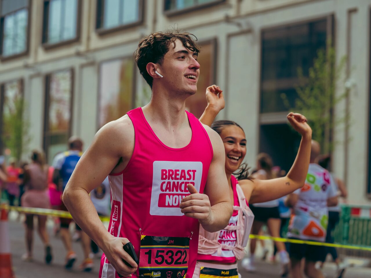People wearing Breast Cancer Now pink running tops whilst running in the street at the London Landmarks half marathon.